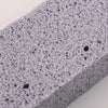 Close-up view of a gray reusable cleaning pumice stone stick with a porous texture.