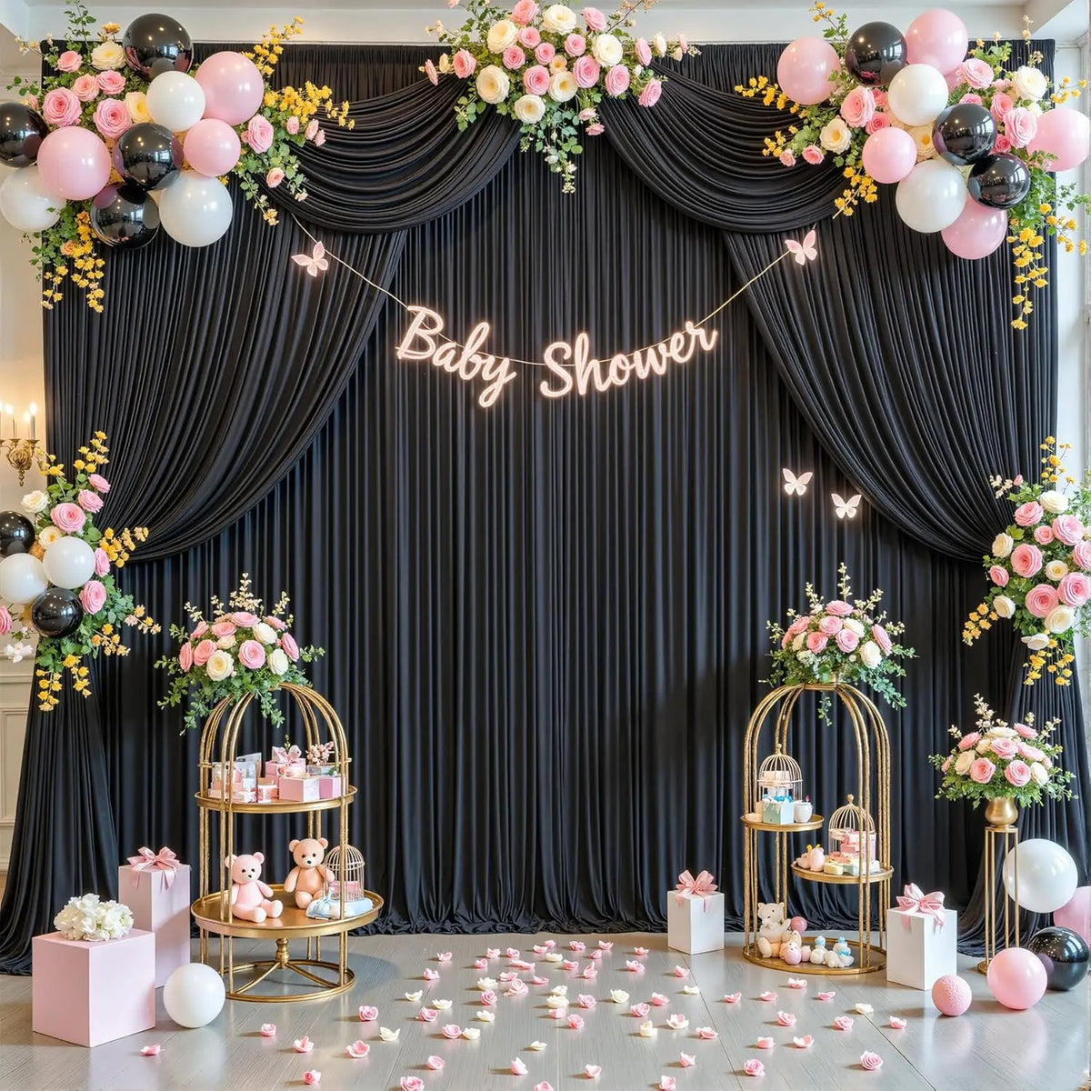 Fondo para baby shower rosa y negro floral con cortinas y soportes dorados decorados.