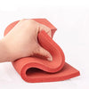 Eine Hand drückt eine rote Silikon-Schaummatte, die ihre flexible und widerstandsfähige Textur demonstriert.