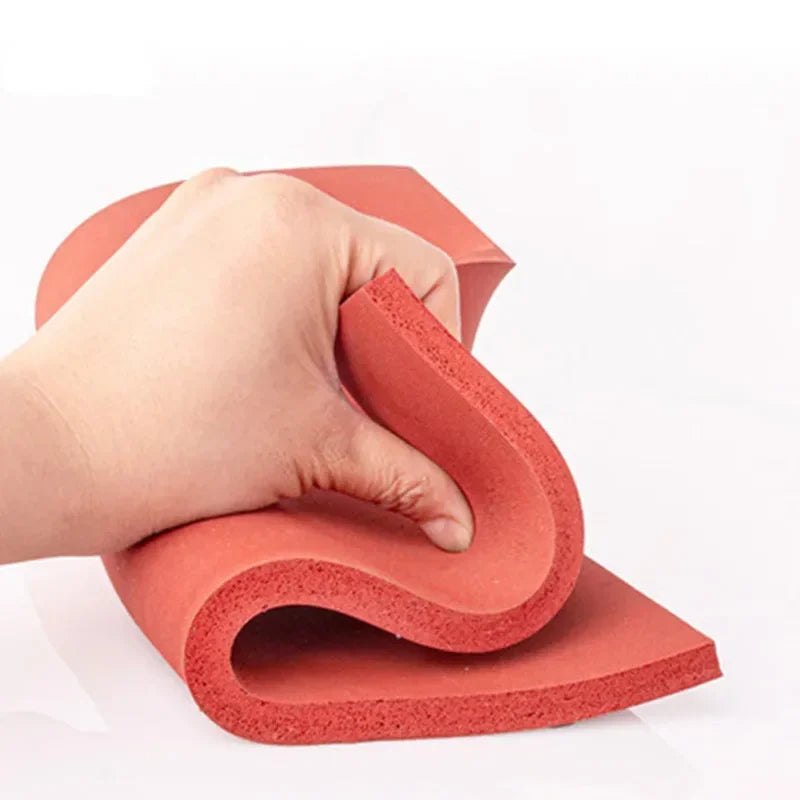 Eine Hand drückt eine rote Silikon-Schaummatte, die ihre flexible und widerstandsfähige Textur demonstriert.