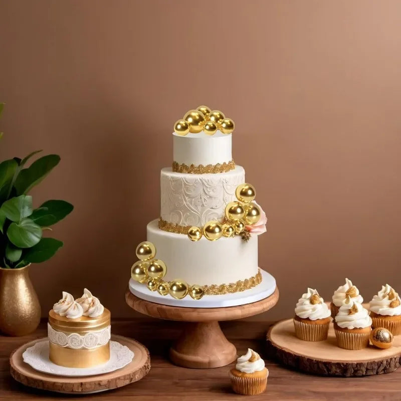 A tiered white cake decorated with gold ball toppers and gold trim on a wooden stand.