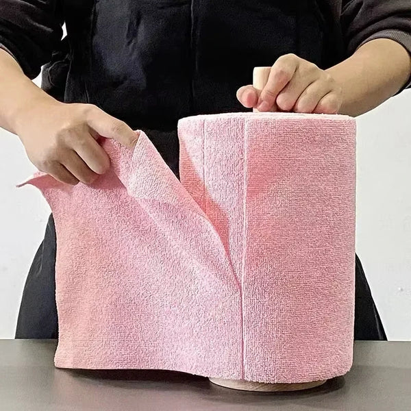 A pink reusable microfiber cleaning wipe is shown being held by a person.