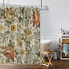 A floral print shower curtain featuring roses and greenery hanging on a metal rod.