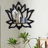 Estante de madera decorativo negro con cristales y flores blancas sobre una pared clara.