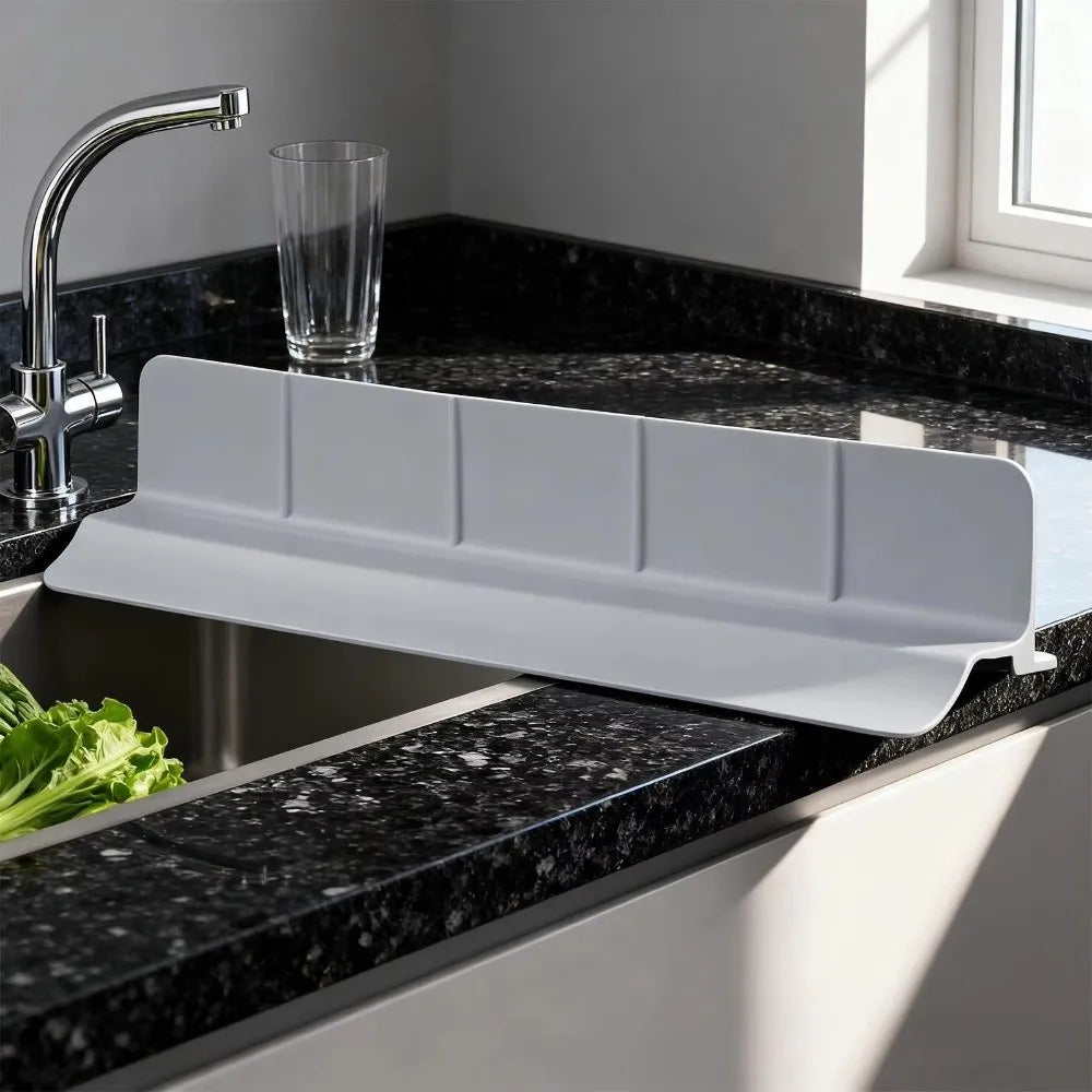 Eine weiße Silikon-Spüle trennt eine schwarze Granit-Küchenspüle.