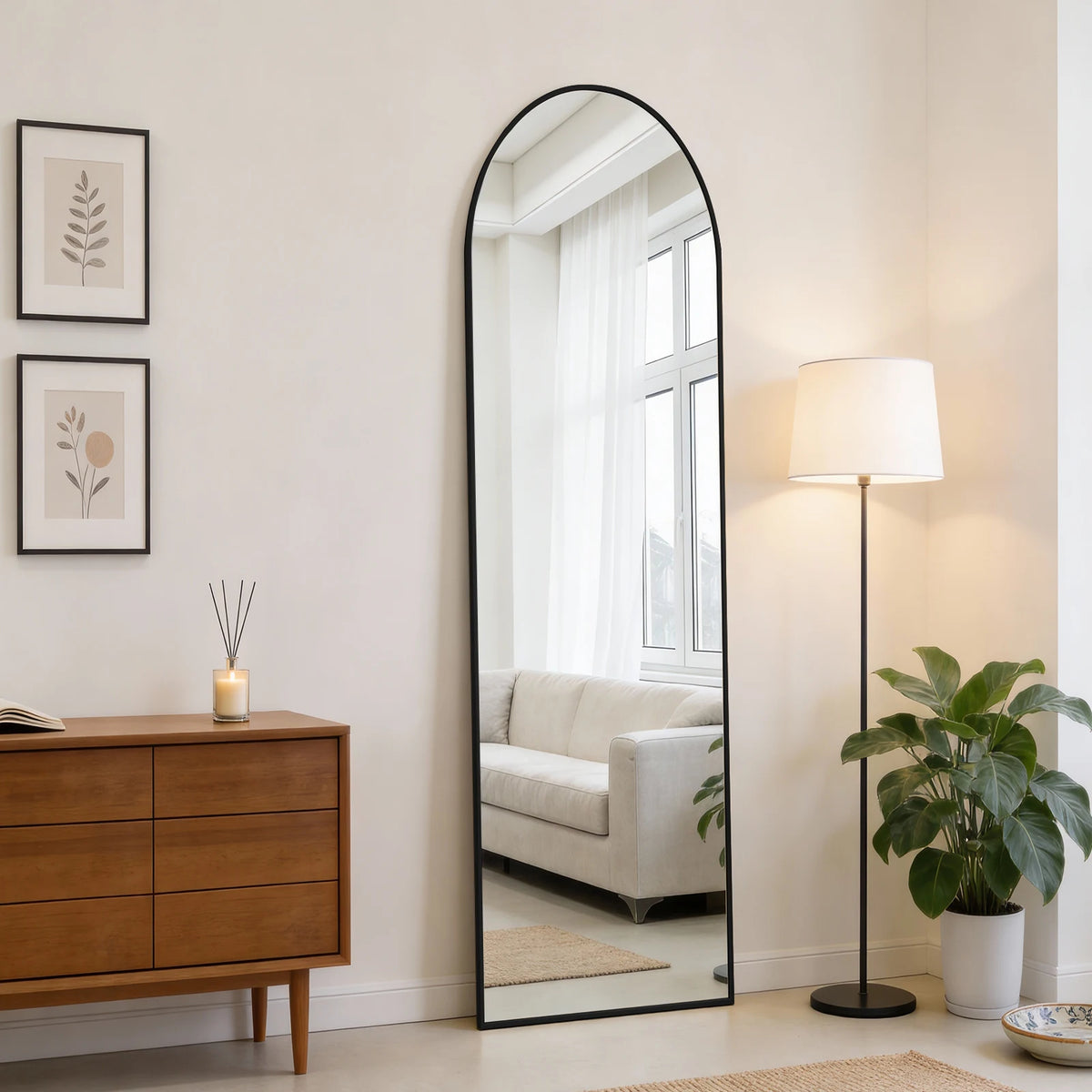 A full body wall mirror with an aluminum frame reflecting a bright room and a window.