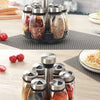 A set of rotating spice jars with metal dispensers filled with various ground spices and seasonings.