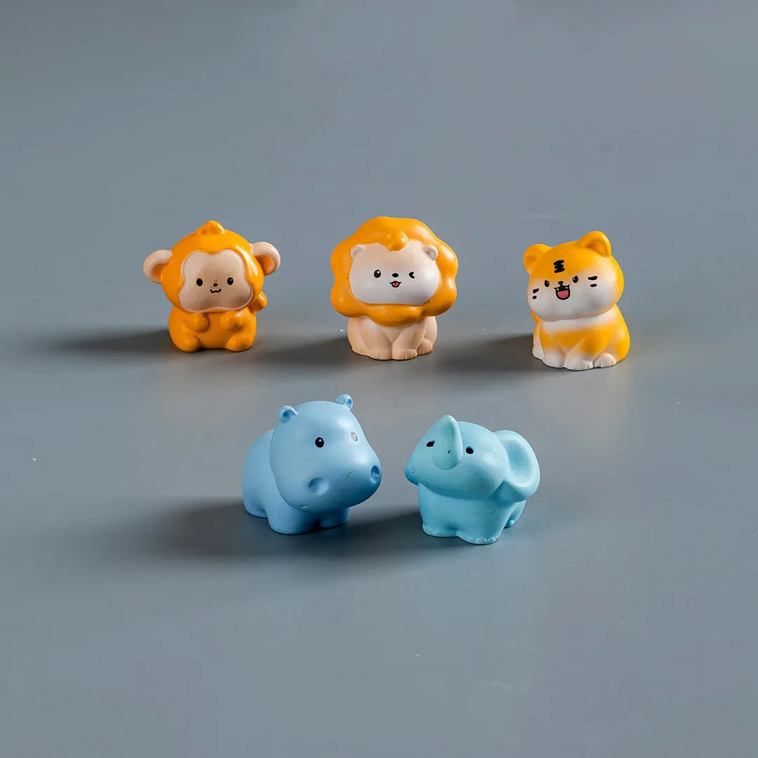 A set of three mini resin cartoon animal figurines, including a yellow lion, a yellow cat, and two blue seals, displayed on a