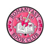 Insignia de esmalte rosa con mariposa y espada de plata sobre un libro abierto con corazón rosa.