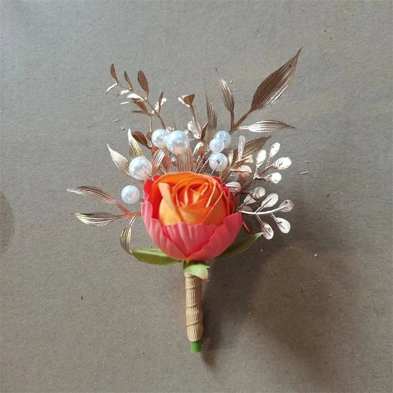 Boutonnière en soie orange vintage avec une rose et un feuillage argenté avec des accents de perles.