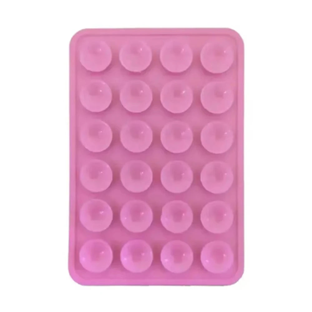 A pink silicone suction cup phone stand with multiple circular grips for hands-free viewing.