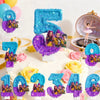 A cake decorated with colorful candles shaped like the number 7 and 1, surrounded by purple and gold glitter.