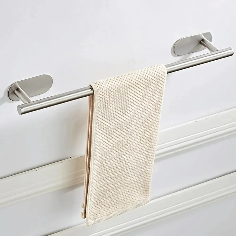 Edelstahl-Handtuchhalter mit beigem geflochtenem Handtuch an einer weißen Wand