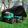 Tiefblaue Arbeitsmaschine mit schwarzer Abdeckung auf grünem Gras.
