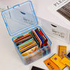 A clear plastic storage box filled with various colored cards and small items, next to a white storage box.