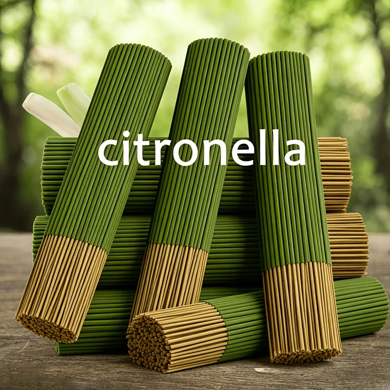 A stack of green citronella oil sticks, some wrapped in natural lemongrass oil, are displayed on a wooden surface.
