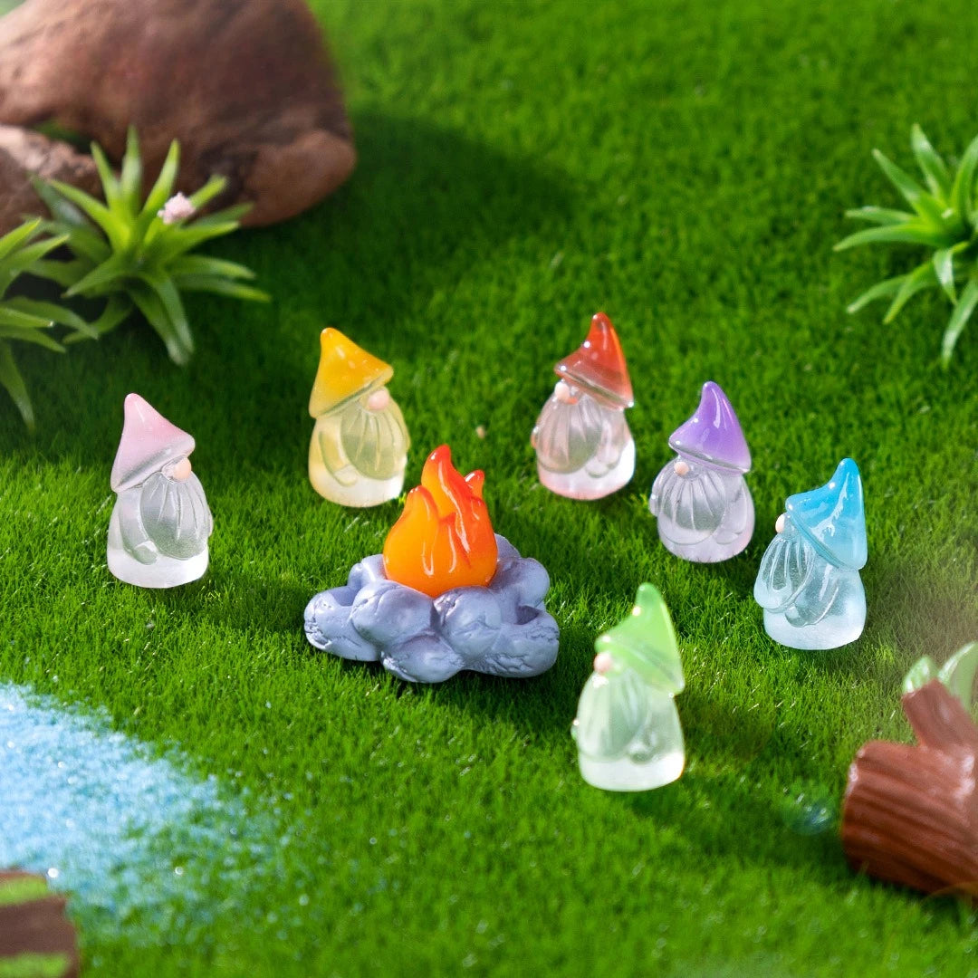 A collection of luminous resin mini fairy gnomes in various colors like yellow, orange, purple, and blue resting on green mos