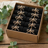 A brown box filled with a pack of ten black microfiber cleaning towels tied with natural twine.