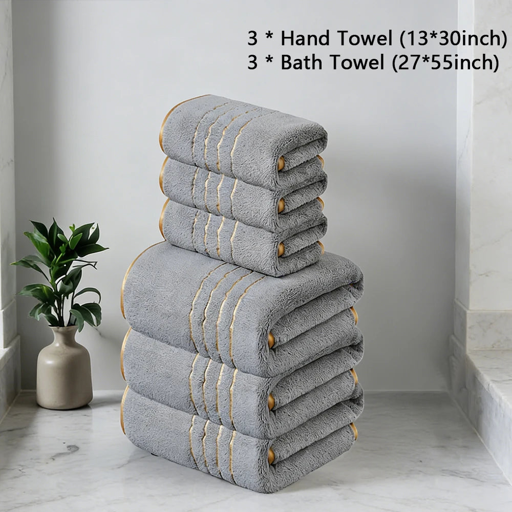 A stack of gray hand and bath towels is displayed on a white marble floor.