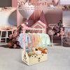 A natural wood storage crate organizer filled with soft toys and clothing items in a pink and white decorative setting.