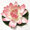 A pink artificial lotus flower with layered petals and a yellow center, resting on a green leaf.