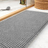 Gray waffle texture non-slip bath mat placed on a light marble surface.