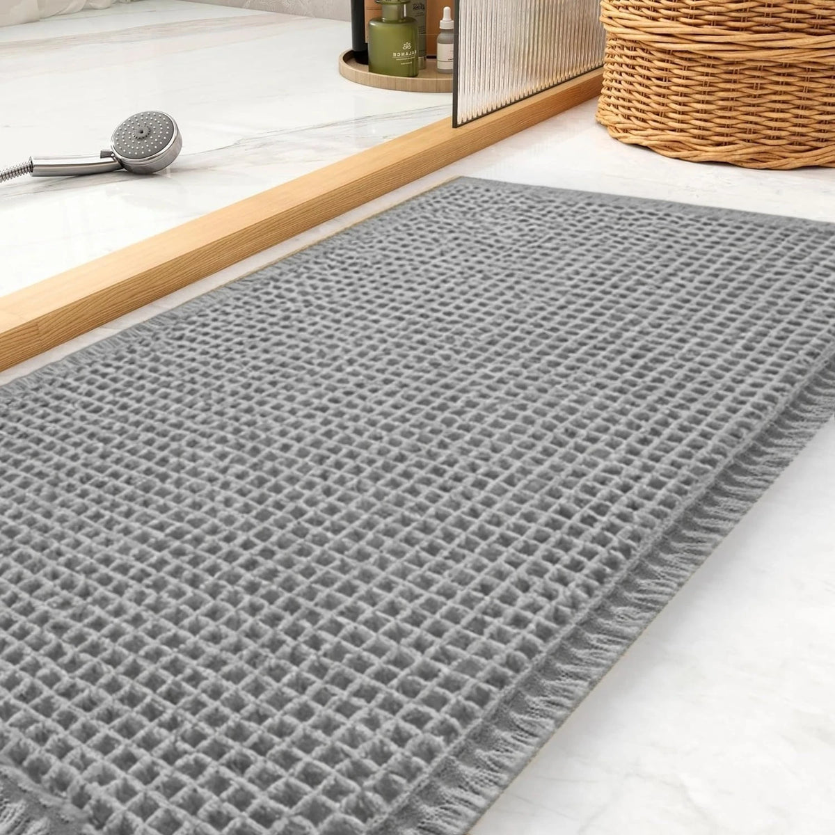 Gray waffle texture non-slip bath mat placed on a light marble surface.