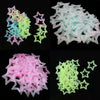 A collection of glow in the dark 3D star wall decals in pink, teal, and lime green.