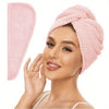 A woman is wearing a pink microfiber hair towel wrap on her head, showing the soft fabric texture.