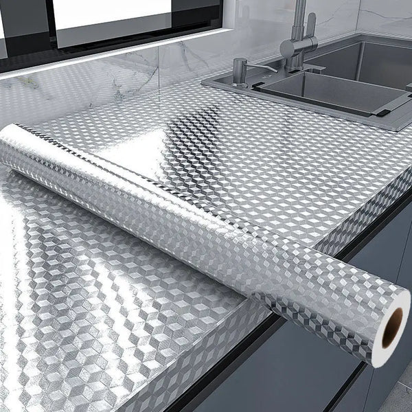 Roll of self-adhesive aluminum foil kitchen wall sticker used as a backsplash protector on a stainless steel sink area.
