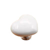 A white heart-shaped toilet presser button with a silver base.