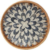Round rattan serving tray with mother of pearl inlay featuring a decorative pattern.