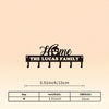 A black silhouette design featuring the words Home The Lucas Family on a metal wall hook key holder.