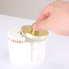 A hand is opening a white plastic organizer designed to hold cotton swabs and makeup accessories.