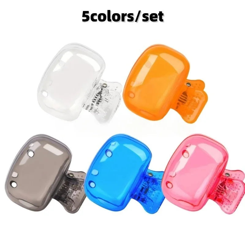 A set of five reusable silicone brush head covers in clear, orange, gray, blue, and pink colors.
