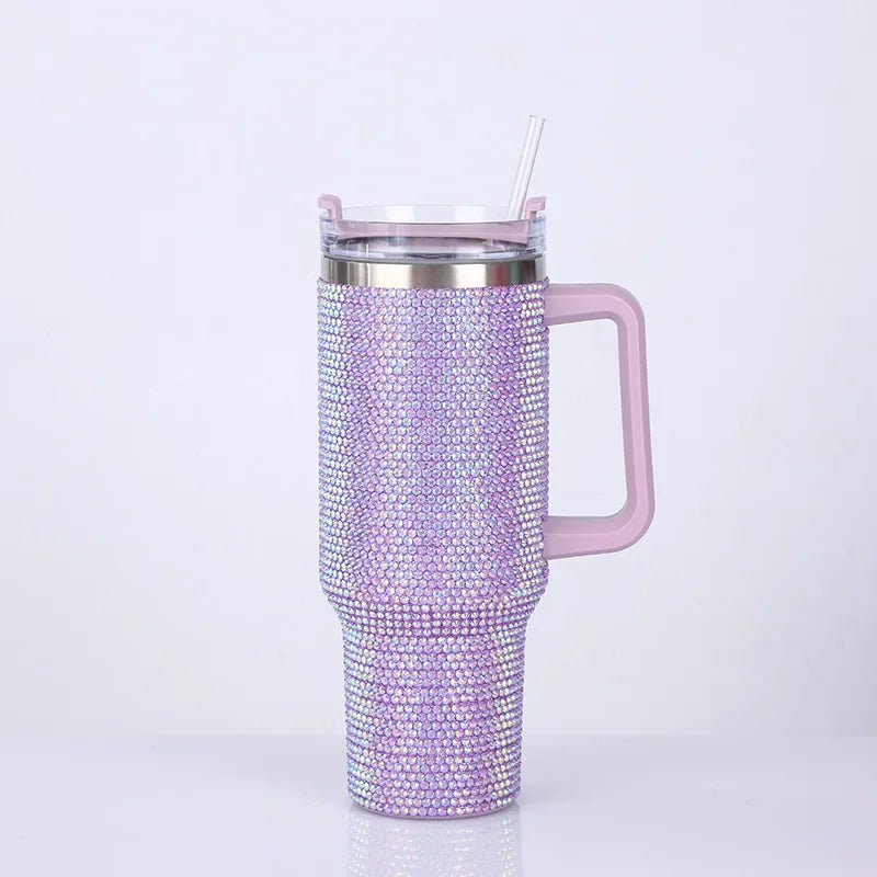 Taza aislada rosa con pedrería, tapa transparente y pajita, con piedras brillantes moradas y plateadas.