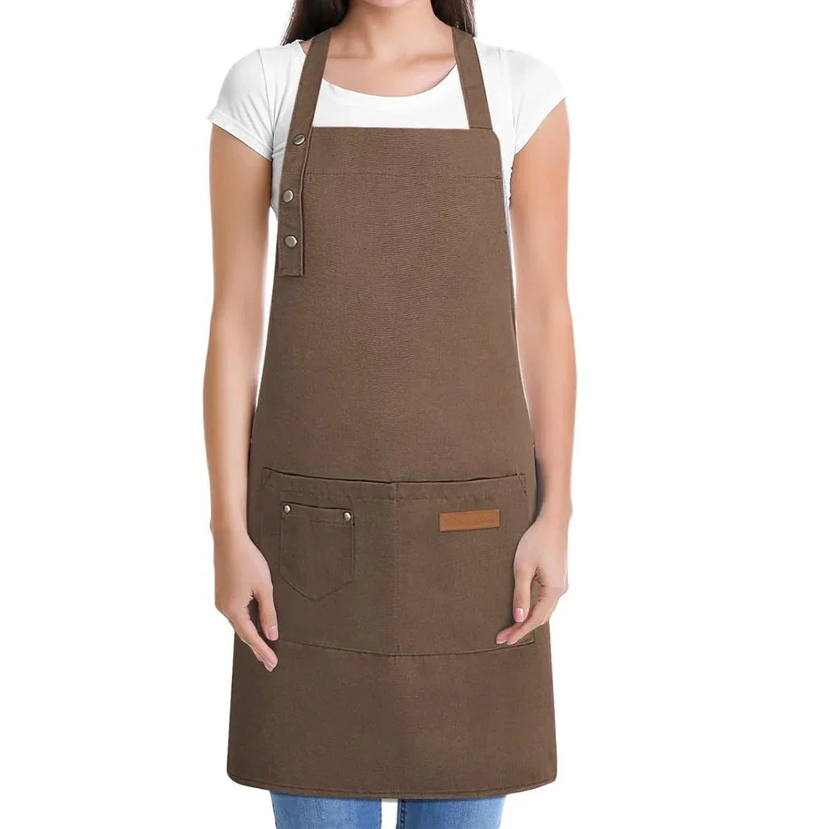 A brown adjustable hairdressing apron worn over a white shirt.