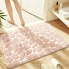 A pink soft pebble embossed bathroom rug placed on a wooden floor near a white radiator.