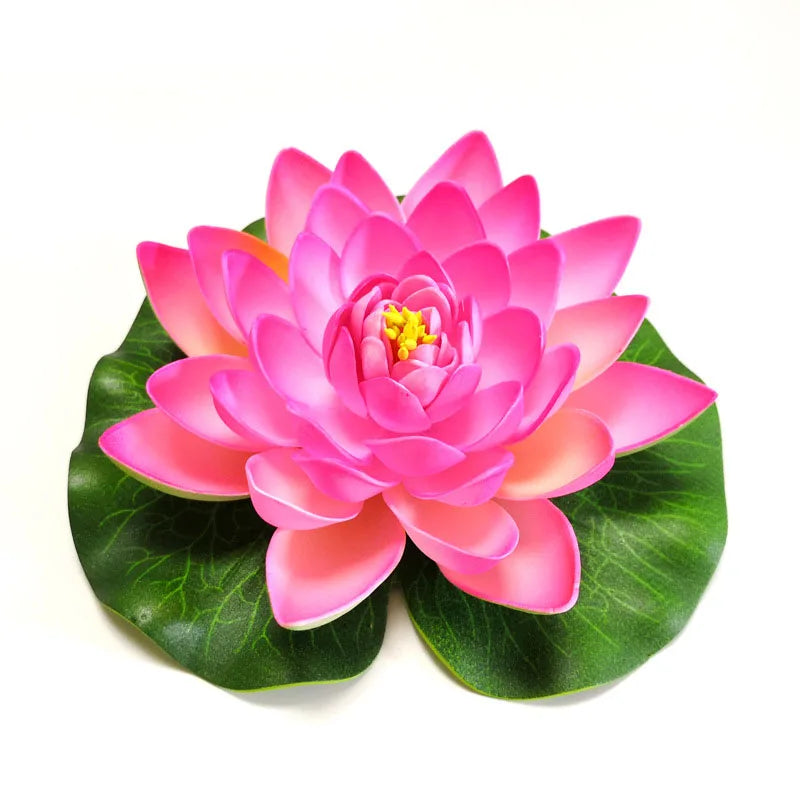 A vibrant pink artificial lotus flower blooming on green leaves.