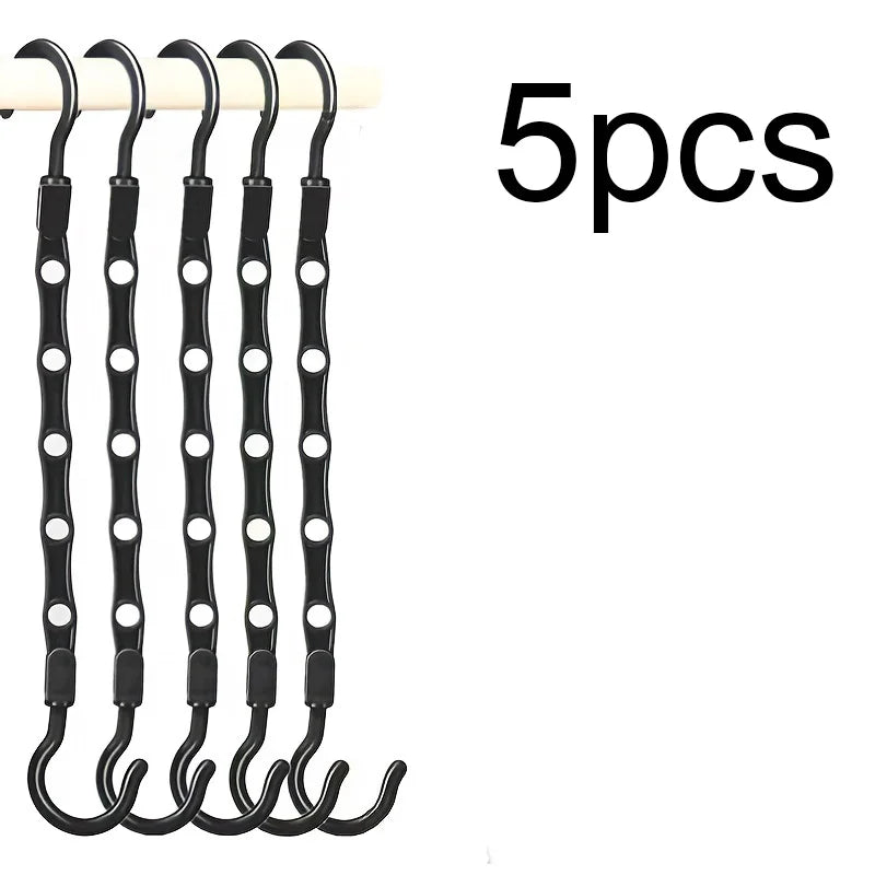 Five black plastic clothes hangers with curved hooks for closet organization