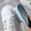 Une main tient une brosse nettoyante bleu clair attachée à une chaussure blanche, démontrant la polyfonctionnalité de la chau