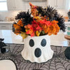 Vase en céramique fait main avec des feuilles d'automne colorées et des baies pour la décoration d'Halloween
