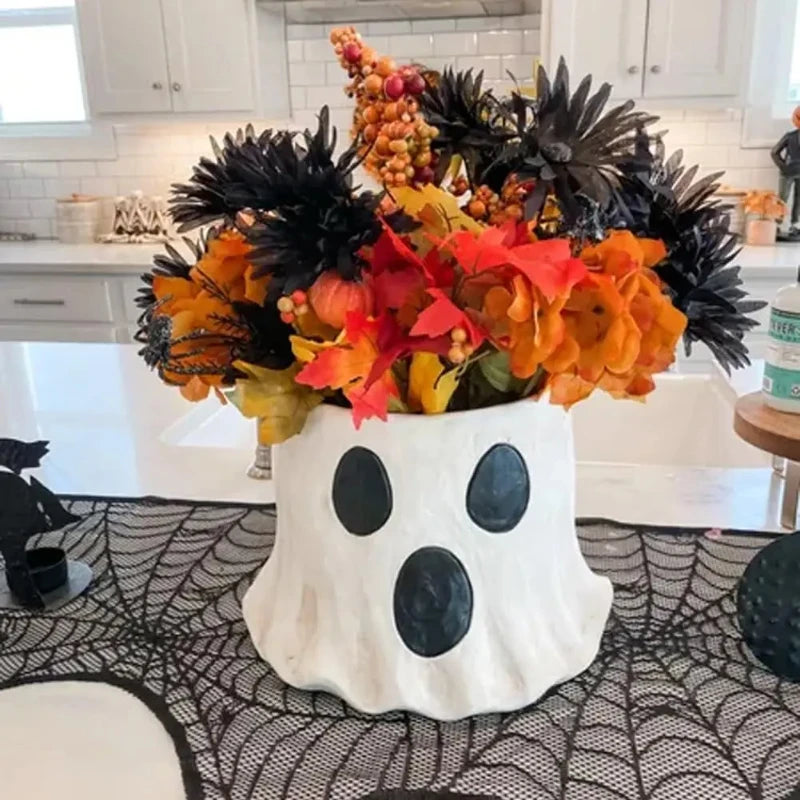 Vase en céramique fait main avec des feuilles d'automne colorées et des baies pour la décoration d'Halloween
