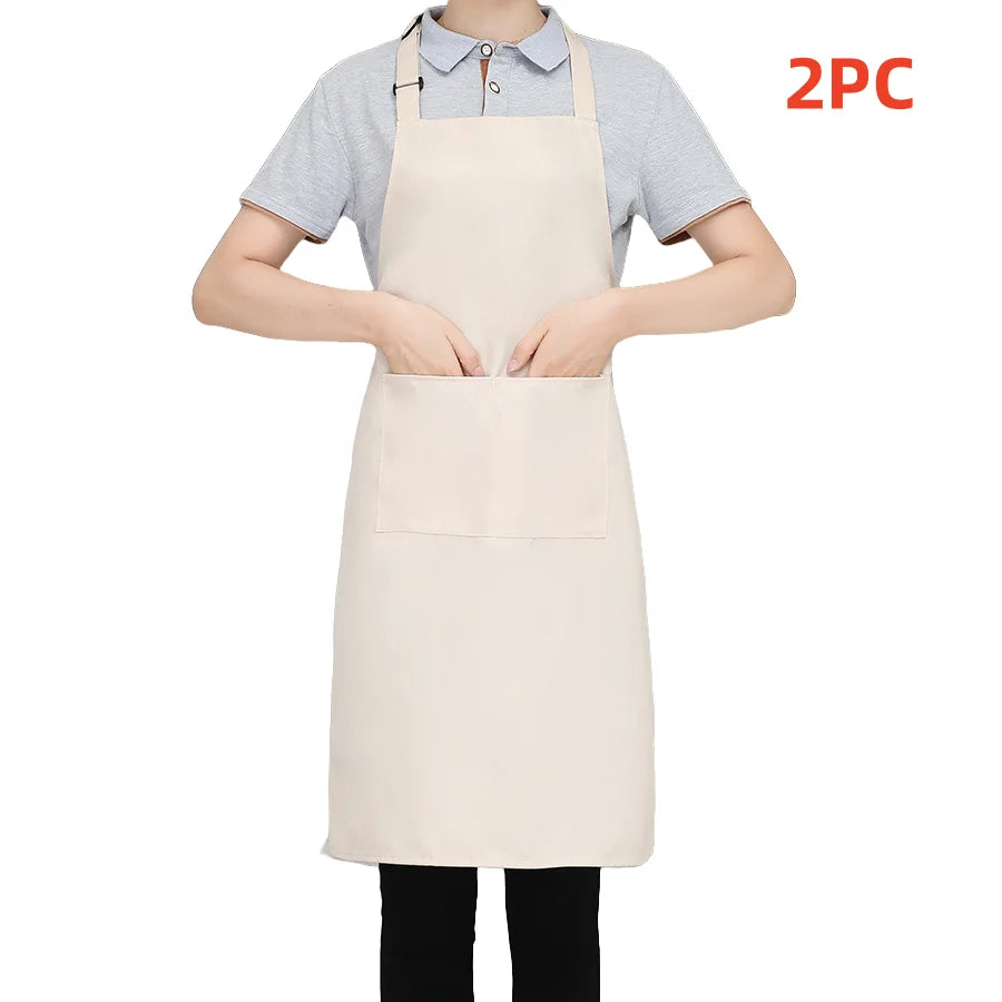 A person is wearing a light beige chef apron over a gray t-shirt, with a second matching apron visible.