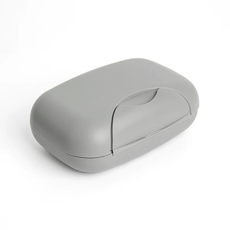 A smooth, gray portable travel soap box with a hinged lid is shown against a white background.