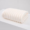 A stack of white thickened microfiber bath towels rolled tightly together.