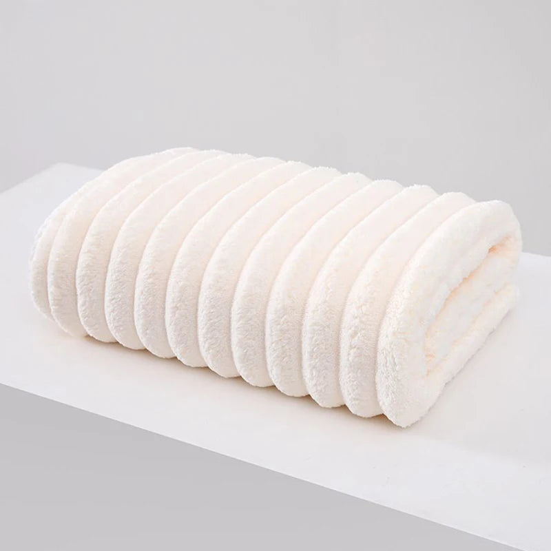 A stack of white thickened microfiber bath towels rolled tightly together.