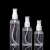 Clear refillable portable spray bottles standing vertically against a black background