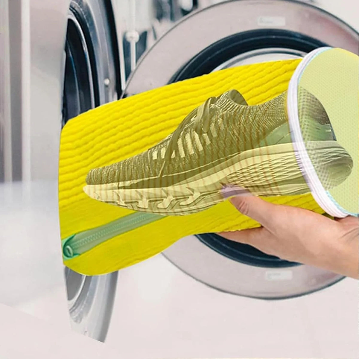 A hand holds a yellow reusable shoe washing bag with soft bristles over a plate.
