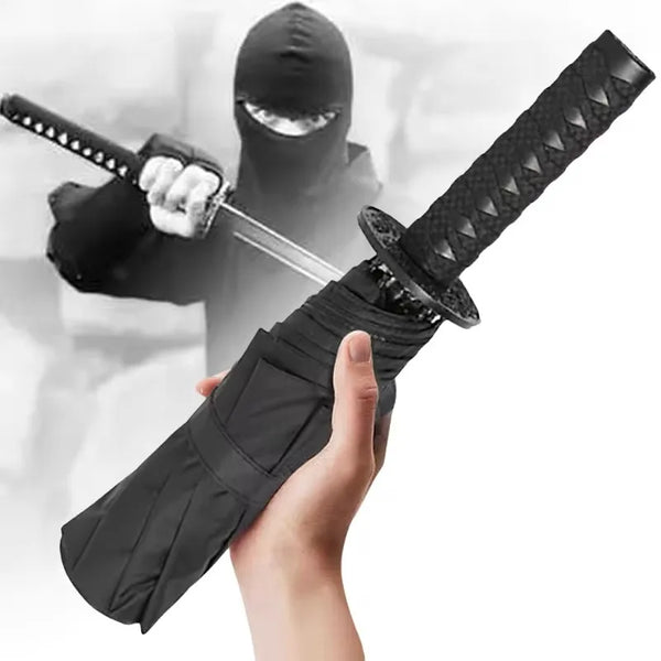 A person in a black hoodie is holding a black folding katana sword with a sheath and scabbard.